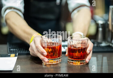 Zwei Gläser Whisky in den Händen eines Barkeeper Stockfoto