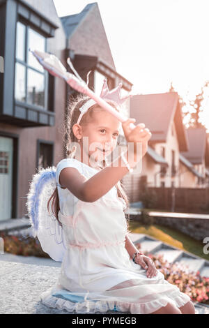 Cute dark-Eyed Girl holding Zauberstab beim Spielen mit Ihrer Familie Stockfoto