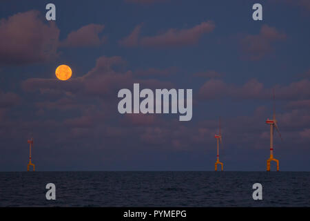 Supermoon und Blut Mond durch die Wolken über Offshore-windfarm, Nordsee, Offshore Stockfoto