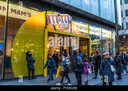 London, Großbritannien - 4. Januar 2018: Logo von M&M's Shop, berühmt durch seine bunten button-geformten Pralinen, mit den Menschen um in London, England Stockfoto