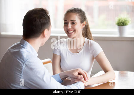 Glückliche Eheleute Reden halten sich an den Händen in der Küche sitzt Stockfoto