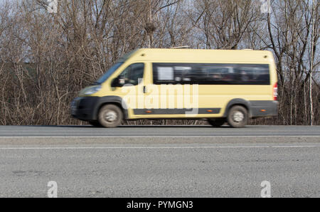 Minibus geht auf das Land Highway entlang der Wald Stockfoto