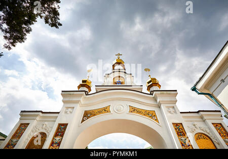 Bogen mit goldenen Kuppeln in Kiew Pechersk Lavra Christian komplexe gegen bewölkten Himmel. Alte historische Architektur in Kiew, Ukraine Stockfoto