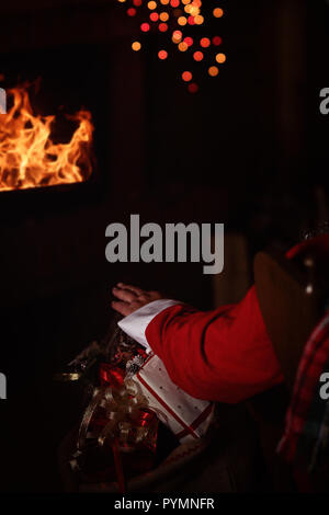 Claus sitzt vor dem Kamin Stockfoto