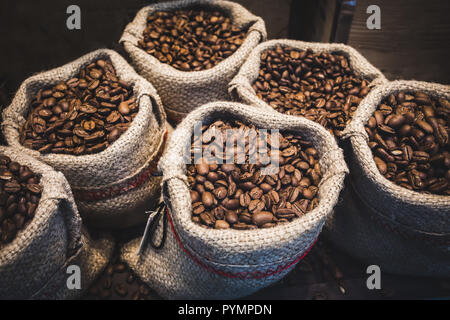 Kaffee Bohnen in Säcke. Kaffee aus frisch gemahlenen Bohnen Hintergrund. Stockfoto