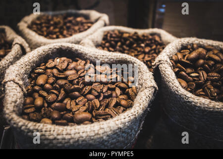 Kaffee Bohnen in Säcke. Kaffee aus frisch gemahlenen Bohnen Hintergrund. Stockfoto