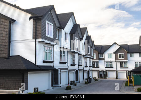 Neue Stadthäuser mit konkreten Bürgersteig vor. Vorderseite von Stadthäusern an einem sonnigen Tag in Kanada. Stockfoto