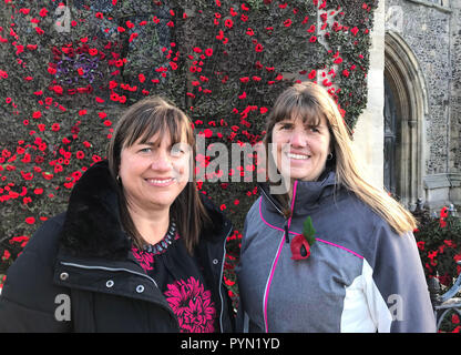 Teresa Elford (links) und Jodie Knospe von Sudbury Stadtrat mit einer Kaskade von gewirkten und gestrickten Mohnblumen hängen von der St. Peter's Kirche in Sudbury zu 100 Jahre Mark seit dem Ende des Ersten Weltkriegs. Stockfoto