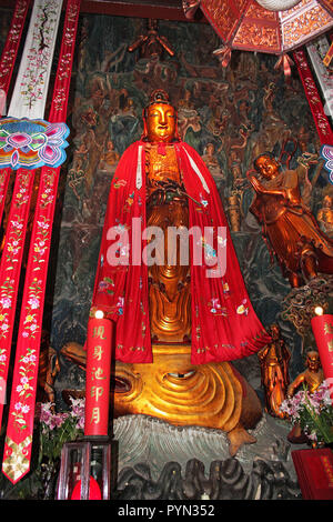 Jade Tempel Buddha Statue in roter Robe mit bunten Symbole und stehend auf der Schlange den Kopf, Shanghai, China Stockfoto