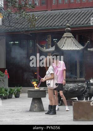 Zwei junge Menschen mit Vermögen -, die Anbetung in der Jing'an Tempel, Shanghai, China Stockfoto