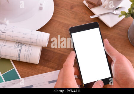 Hände mit Smartphone in einem Architekturbüro. Konzept des Sehens in der mobilen ein Bild in den Bau. Ansicht von oben Stockfoto