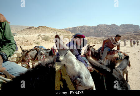 Bedouin Männer und Jungen neigen dazu, ihre Esel, Pferde und Kamele, Fahrten für Touristen in der Petra Archäologischen Park zu bieten, in Jordanien am 29. Oktober 2018 Stockfoto