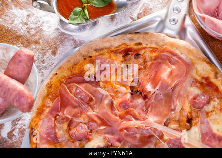 Nahaufnahme der leckere Pizza mit Wurst, Schinken und geräuchertem Fleisch Stockfoto