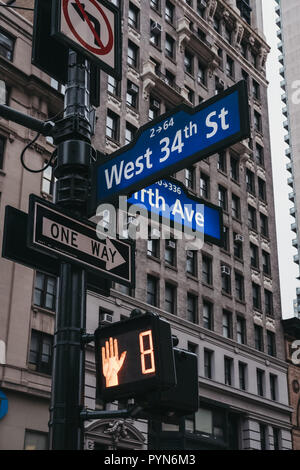 Straße und Schilder auf einen Laternenpfahl an der Ecke Fifth Avenue und West 34th Street in Manhattan, New York, USA. Stockfoto