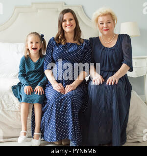 Lachen, Mutter, Tochter, Großmutter. Ältere Frau, schwanger nach Frau und Kind Mädchen zu Hause. Gerne weibliche Generation. Stockfoto