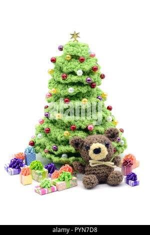 Häkeln Weihnachtsbaum mit Perlen auf weißem Hintergrund isoliert. Geschenke unter dem Baum. Stockfoto