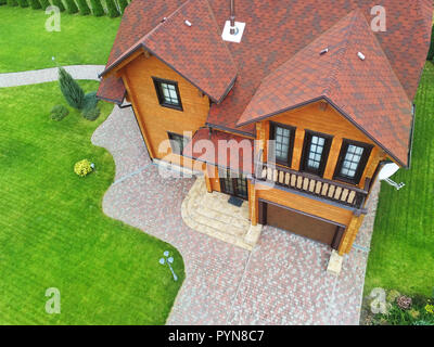 Schönen Luxus big Holzhaus. Holz Landhaus Villa mit grünem Rasen, Garten und blauer Himmel im Hintergrund Stockfoto
