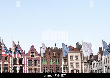 Fantastische Aussicht auf den Markt (der Markt) mit seinen farbenfrohen Flämischen Gebäuden und belgischen Fahnen in Brügge, Belgien, Flandern, Europa. Die zum UNESCO-Weltkulturerbe zählt. Stockfoto