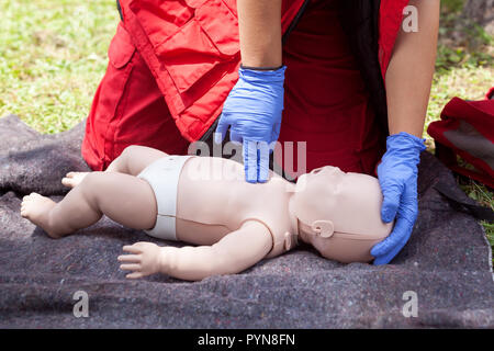 Demonstration der kardiopulmonalen Reanimation auf einer Hlw-Baby dummy während der Schulung in erster Hilfe. Stockfoto