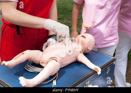 Demonstration der kardiopulmonalen Reanimation auf einer Hlw-Baby dummy während der Schulung in erster Hilfe. Stockfoto