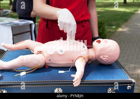 Demonstration der kardiopulmonalen Reanimation auf einer Hlw-Baby dummy während der Schulung in erster Hilfe. Stockfoto