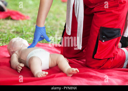 Demonstration der kardiopulmonalen Reanimation auf einer Hlw-Baby dummy während der Schulung in erster Hilfe. Stockfoto