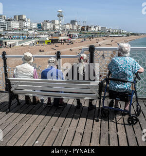 Sitzende Leute am Brighton Pier Stockfoto