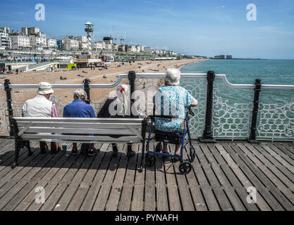 Sitzende Leute am Brighton Pier Stockfoto