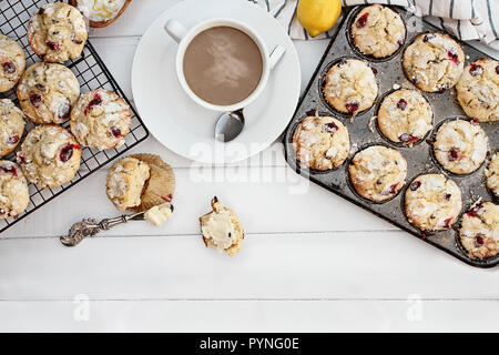 Heiß dampfenden Kaffee und Cranberry Muffins mit Butter über eine rustikale weißem Hintergrund. Bild geschossen von oben mit freier Platz für Text. Stockfoto