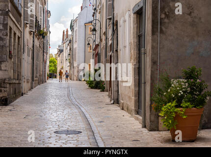 Orleans, Frankreich - 11 August, 2018: die kleine Gasse mit Touristen - Mann und Frau Hand in Hand - mit alten hohen Häuser mit nostalgischen Lampen und Pflanzen Stockfoto