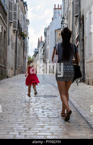 Orleans, Frankreich - 11 August, 2018: die kleine Gasse mit trunning Kind und Frau und mit alten hohen Häuser mit nostalgischen Lampen und Pflanzen in Orle Stockfoto