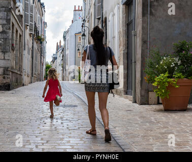 Orleans, Frankreich - 11 August, 2018: die kleine Gasse mit trunning Kind und Frau und mit alten hohen Häuser mit nostalgischen Lampen und Pflanzen in Orlea Stockfoto