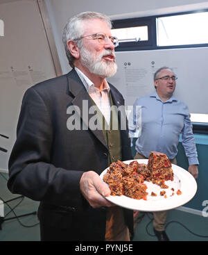 Der ehemalige Sinn-Fein-Anführer Gerry Adams übergibt den Medien Weihnachtspudding bei der Veröffentlichung seines Rezepturbuches mit dem Titel The Negotiators' Cookbook im Culturlann on the Falls Road in Belfast. Stockfoto