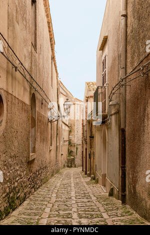 Schmale Straße mit Kopfsteinpflaster in der mittelalterlichen Festungsstadt Erice, Sizilien, Süditalien. Stockfoto