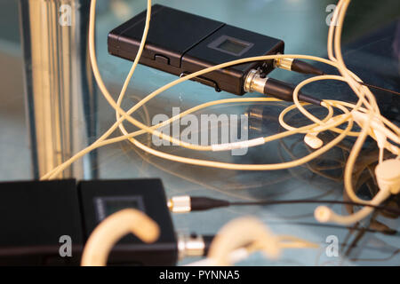 Head Set drahtlose Mikrofone drahtlose Mikrofone Sender und zwei Empfänger auf Glas Tisch im TV-Studio Stockfoto