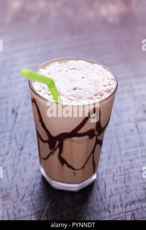 Weiß frappe Kaffee Glas mit iced Drink auf einem dunklen hölzernen Tisch in einem Cafe. Stockfoto