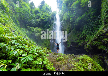 Frau genießen und entspannen vor dem Laangan Munduk Wasserfall im Wald, Insel Bali, Indonesien Stockfoto