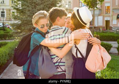 Gruppe von glücklich Jugendliche 13, 14 Jahre zu Fuß entlang der Straße der Stadt, Freunde umarmen. Freundschaft und Personen Konzept Stockfoto
