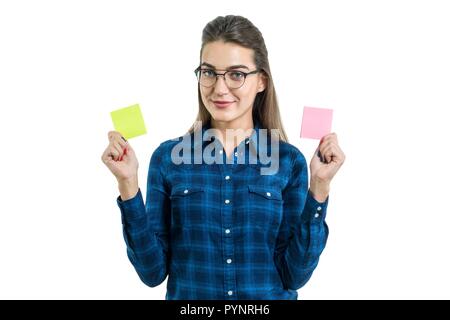 Junge Frau trifft eine Auswahl. Foto isoliert ist, Frau hält zwei sauber Aufkleber in verschiedenen Farben, Platz für Ihren Text. Stockfoto