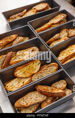 Scheiben geröstetes Brot mit Olivenöl und Knoblauch in der Pfanne bereit zu dienen Stockfoto