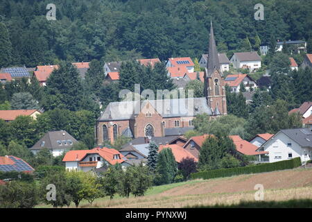 Die katholische Kirche St. Andreas gebaut von 1898/1901, in Reimsbach Blick aus dem Südwesten, blauer Himmel und Sonnenschein, gesehen von Südwesten Stockfoto
