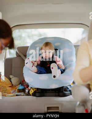 Porträt von einem Kleinkind im Auto Sitz sitzt hinten im Auto der Mutter. Stockfoto