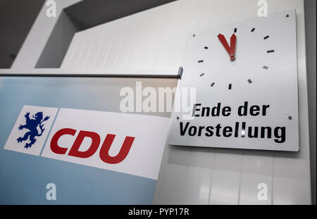 Hofheim, Deutschland. 29 Okt, 2018. Ein Vertreter der hessischen CDU (L) stehen vor einer Uhr, die die "Ende der Leistung" bei fünf Minuten vor Zwölf auf einem kleinen CDU-Parteitag über das Ergebnis der Landtagswahl in Hessen in der Stadthalle. Foto: Frank Rumpenhorst/dpa/Alamy leben Nachrichten Stockfoto