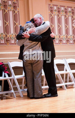 Pittsburgh, USA. 28 Okt, 2018. Rabbiner Jeffrey Myers, Rabbi Cheryl Klein, und Rabbi Jonathan Perlman teilen eine herzliche Umarmung nach dem Memorial Services. In Pittsburgh, Pennsylvania, Tausende kamen zusammen, um den Verlust der Baum des Lebens Synagoge schießen in Squirrel Hill, wo 11 Kongregationsmitglieder getötet und sechs Verletzte zu beklagen. Die tödlichste Angriff auf die Juden in der Geschichte der Vereinigten Staaten. Interreligiöse Führer in die Tausende ihre Solidarität zu zeigen und die Stimme ihre Liebe und Einheit für alle Menschen, unabhängig von Rasse und Religion. Die mahnwache wurde auf die Soldaten & Sai gehalten Stockfoto