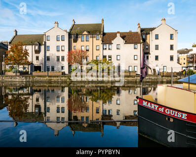 Die Shore, Leith, Edinburgh, Schottland, Vereinigtes Königreich. 30 Okt, 2018. UK Wetter: Sonnenschein am Leith schafft bunte Reflexionen der Riverside Gebäude im Wasser des Leith River. Moderne Wohnungen in der Wasser- und der Bug eines angelegter Lastkahn, genannt Maria von Guise wider Stockfoto