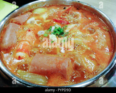 Leckeres koreanisches Essen Yukgaejang spicy Seafood Suppe, Yukgaejang Hot Pot ist Koreanisch Eintopf mit Kimchi, Nudeln, Schinken, Wurst, Muscheln, Garnelen und Gemüse gemacht Stockfoto