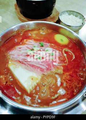 Leckeres koreanisches Essen Yukgaejang würziges Rindfleisch Suppe, Yukgaejang Hot Pot ist Koreanisch Eintopf mit Kimchi, Nudeln, Käse, Schinken, Wurst, Muscheln, Garnelen ein Stockfoto