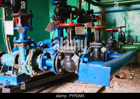 Mehrere alte schwarze Fensterläden mit roten Griffe an der Kaltwasserleitung farbig in Blau. Stockfoto