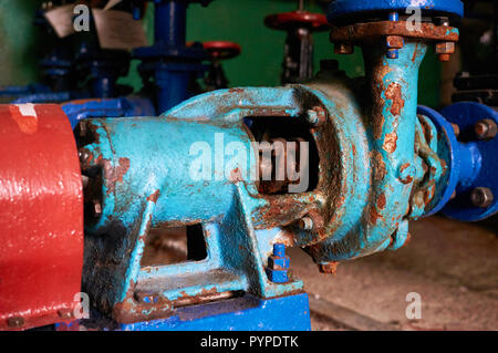 Alte, rostige mit Kratzern Wasser-Pumpe blau auf das kalte Wasser Pipeline blau lackiert lackiert. Stockfoto