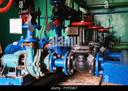 Mehrere alte schwarze Fensterläden mit roten Griffe an der Kaltwasserleitung farbig in Blau. Stockfoto